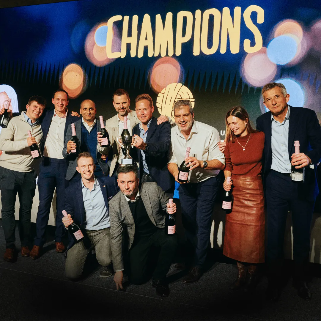 The champions of the Sports Quiz 2025 celebrate on stage with bottles of champagne